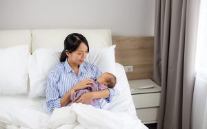 New mother holding newborn baby for secondary infertility support.