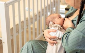 New mother breastfeeding her infant to support milk supply.
