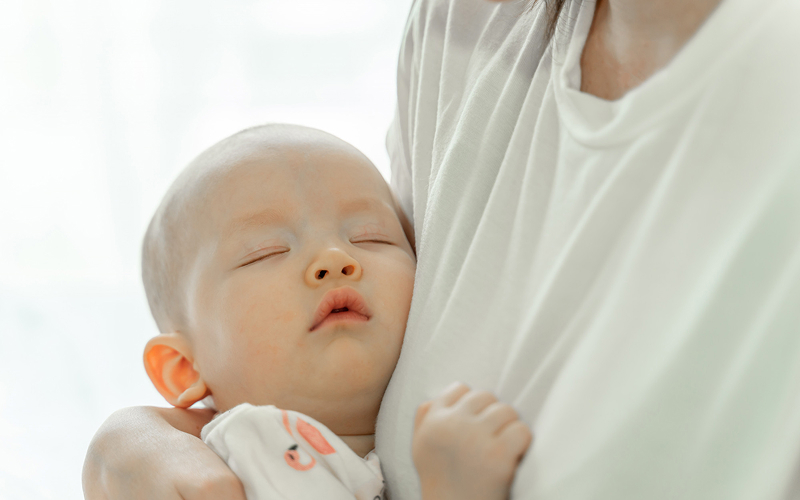 Infant sleeping peacefully after successful feeding and care session.