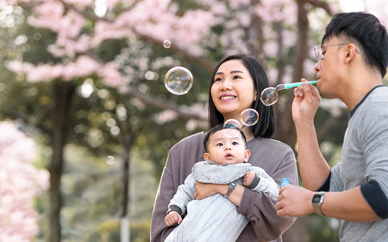 Happy family in a park with bubbles.