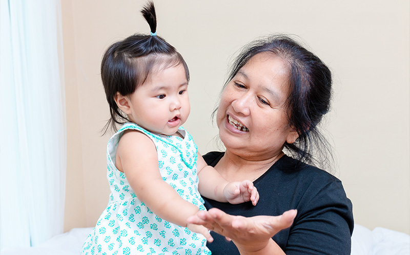 Grandmother holding her grandchild and smiling