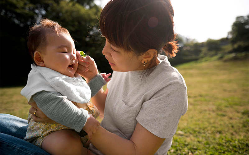 Mother playing with her baby outdoors