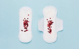 Sanitary pads with red sequins representing irregular bleeding patterns.