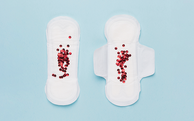 Sanitary pads with red sequins representing irregular bleeding patterns.